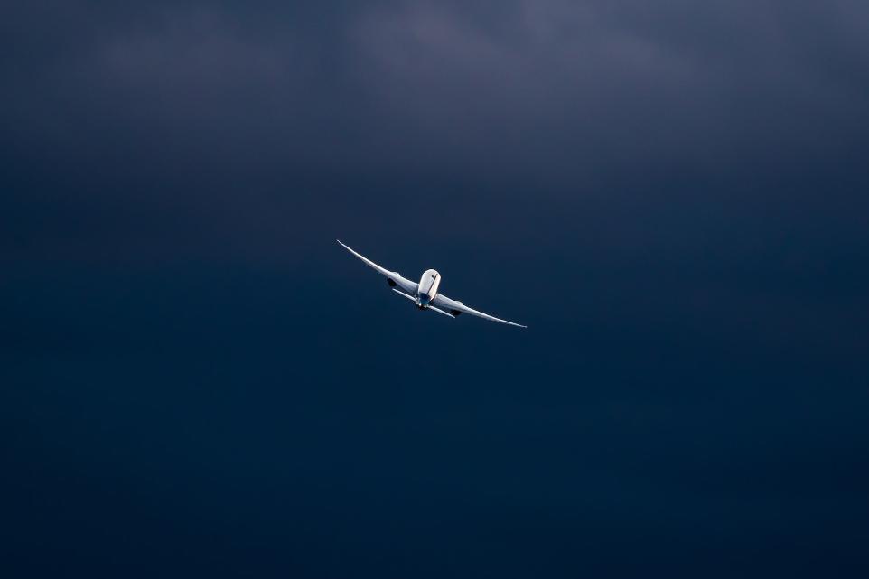 white airplane in mid air during daytime